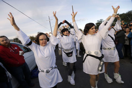 Members dressed as Princess Leia, in honor of actress Carrie Fisher, who played Leia in the Star Wars movie series, in New Orleans, Friday, Dec. 30, 2016.